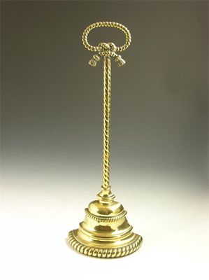 Appraisal: A Victorian brass door stop with rope borders and stem