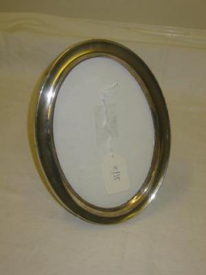 Appraisal: A PHOTOGRAPH FRAME of oval form with oak strut back