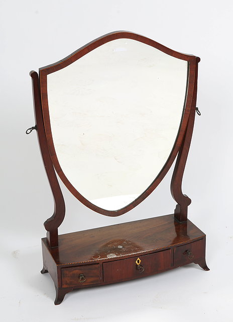 Appraisal: A GEORGE III MAHOGANY SWING TOILET MIRROR with shield shaped