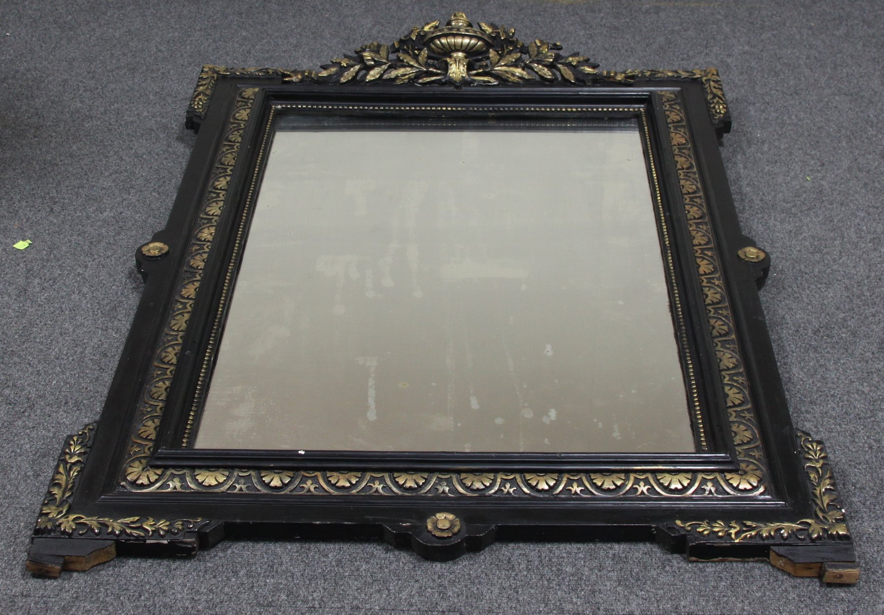 Appraisal: A gilt and ebonised wall mirror with squared corners having