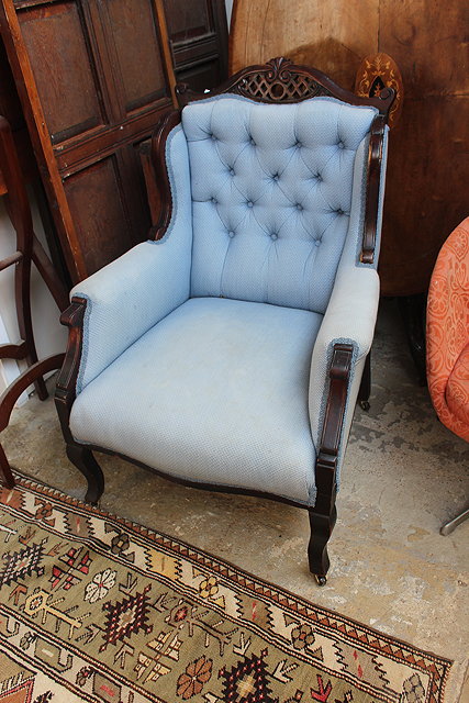 Appraisal: A PAIR OF MAHOGANY BLUE BUTTON UPHOLSTERED ARMCHAIRS with wing