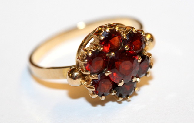 Appraisal: A GARNET SET CLUSTER RING seven claw set garnets mounted