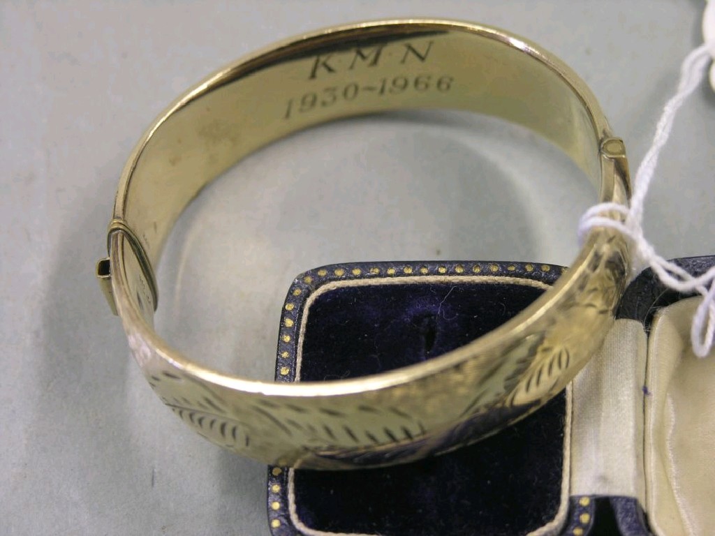 Appraisal: A ct gold bangle with engraved ornament personalised metal core