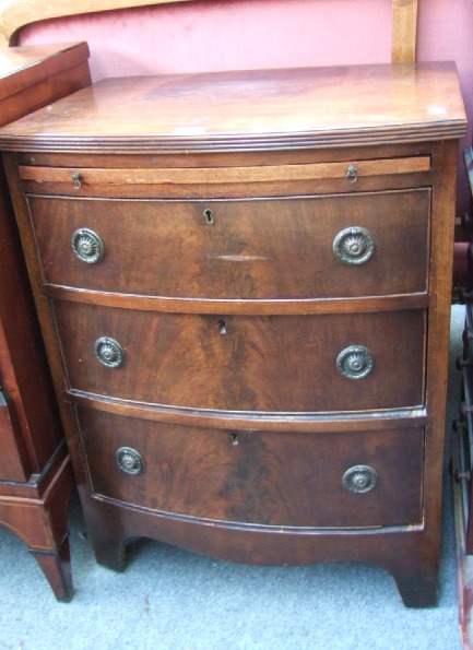 Appraisal: A small Regency style mahogany bowfront chest the brushing slide