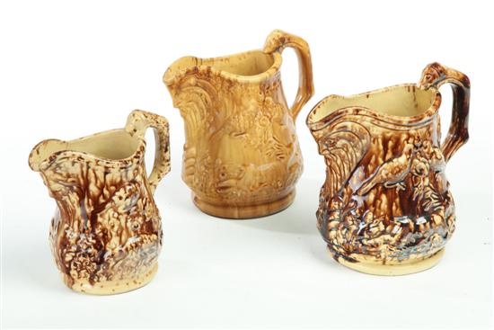 Appraisal: THREE ROCKINGHAM PITCHERS Two matching and one single mottled glazed