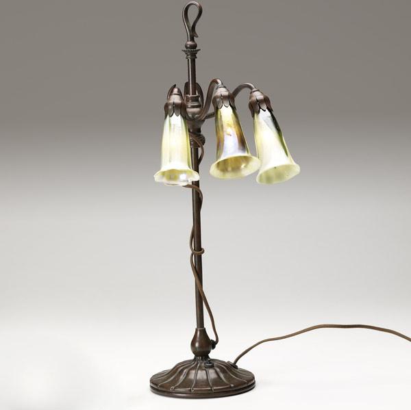 Appraisal: TIFFANY STUDIOS Early three-light Lily lamp with a fluted and