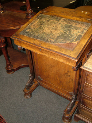 Appraisal: A Victorian walnut davenport with hinged compartment above sloped writing