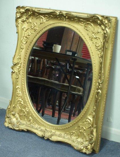 Appraisal: An oval wall mirror with C-scroll and acanthus border and