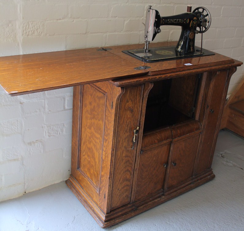 Appraisal: An early thC Singer sewing machine on an articulated oak