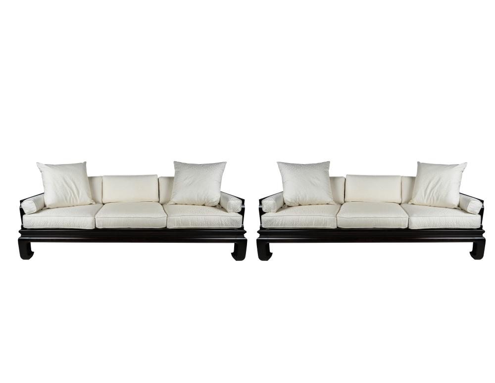 Appraisal: TWO ASIAN STYLE WOOD-FRAMED SOFAScovered with geometrically patterned white damask