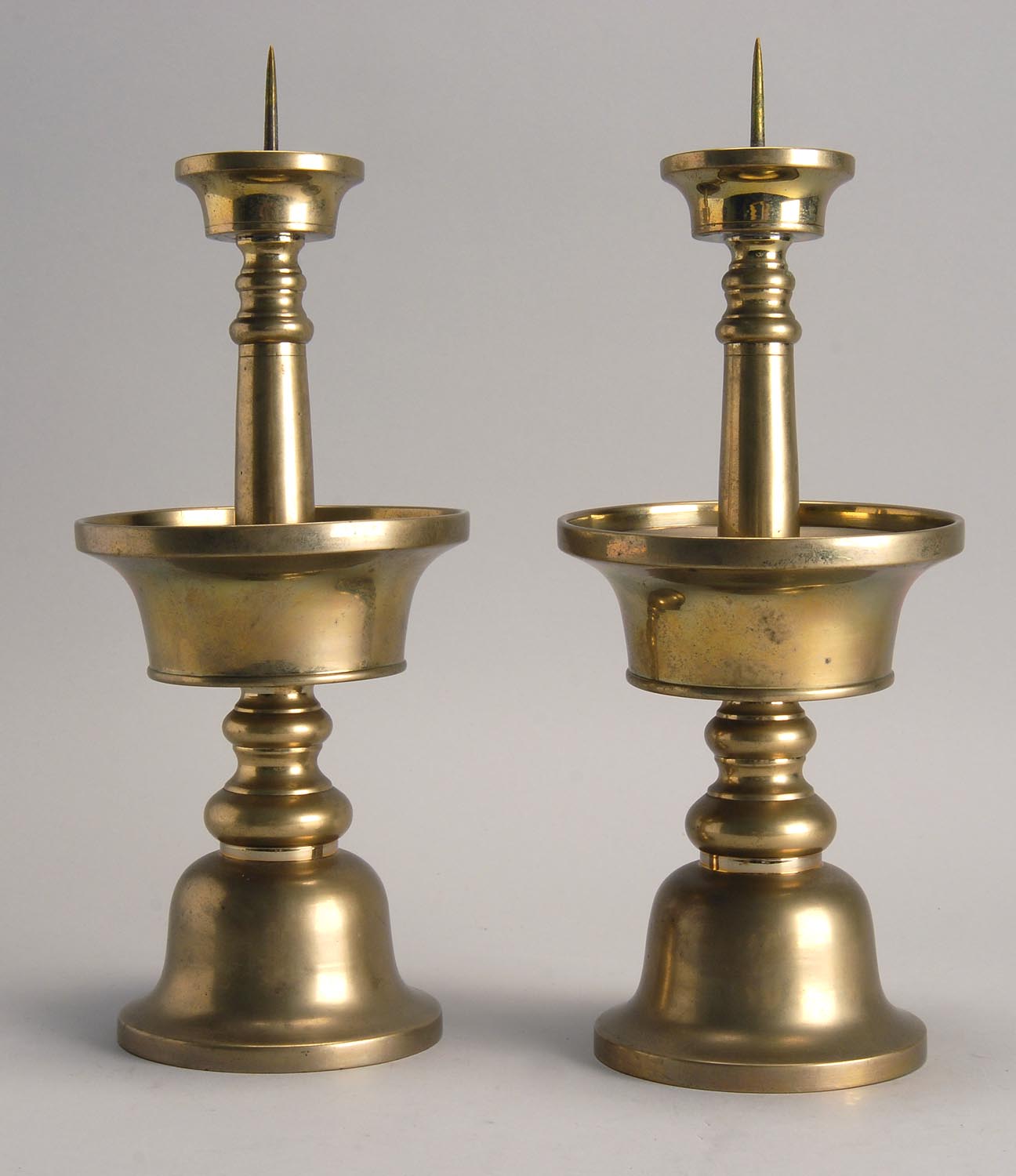 Appraisal: PAIR OF BRASS PRICKET CANDLESTICKS With bell-form foot and dish-form