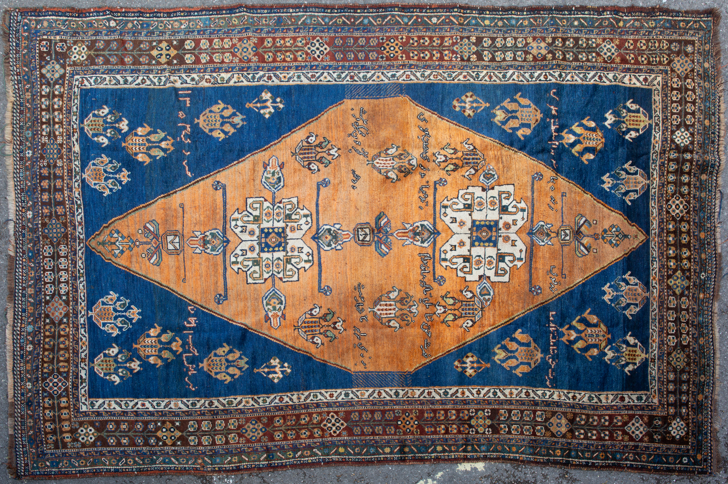 Appraisal: An antique Shiraz brown ground rug with inscription the central