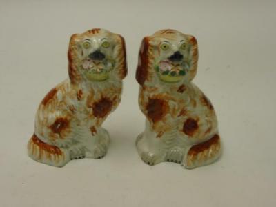 Appraisal: A PAIR OF STAFFORDSHIRE POTTERY DOGS th century modelled seated