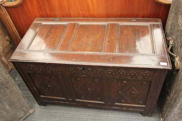 Appraisal: AN ANTIQUE OAK COFFER with triple panelled top and chip