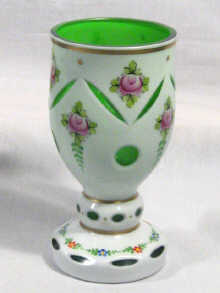 Appraisal: A green glass vase with milk glass overlay panel cut