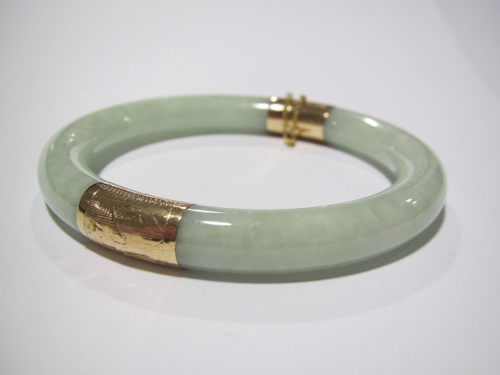 Appraisal: Fourteen carat gold mounted jade bangle