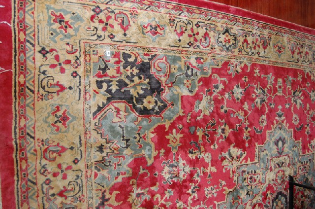 Appraisal: A LARGE PERSIAN RUG The foliate field on a red