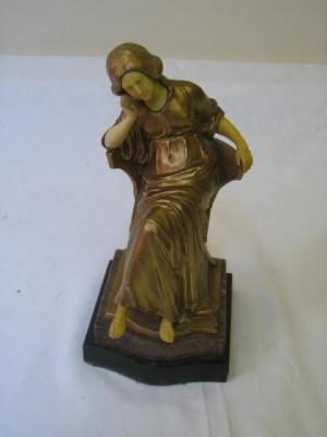 Appraisal: A GILDED METAL FIGURE modelled as a seated lady with