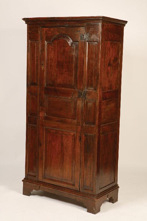 Appraisal: A GEORGE III OAK PANELLED CUPBOARD with a two part