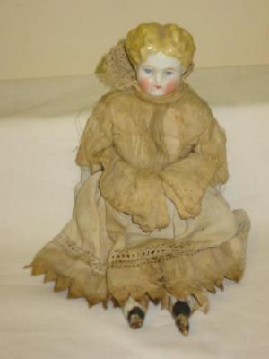 Appraisal: A china shoulder head doll with painted face moulded hair