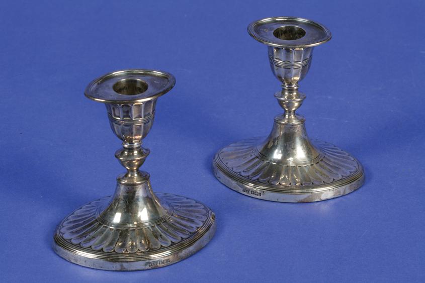 Appraisal: A PAIR OF EDWARDIAN DWARF CANDLESTICKS with urn-shaped capitals on