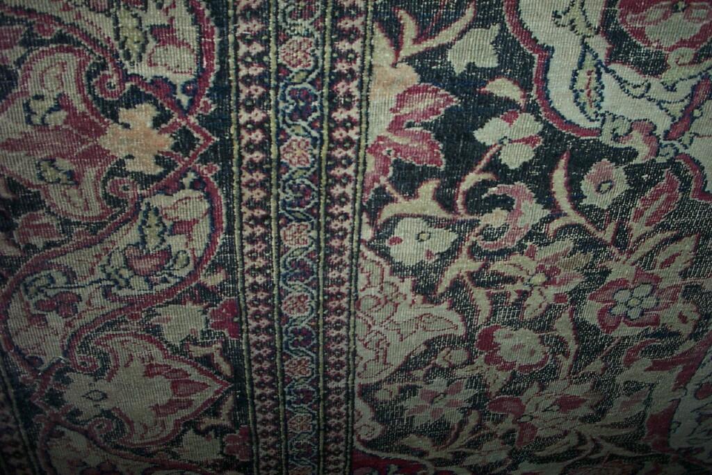 Appraisal: An Eastern wool rug with stylised floral decoration in red