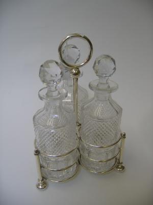 Appraisal: AN EDWARDIAN THREE BOTTLE DECANTER STAND of plain trefoil form