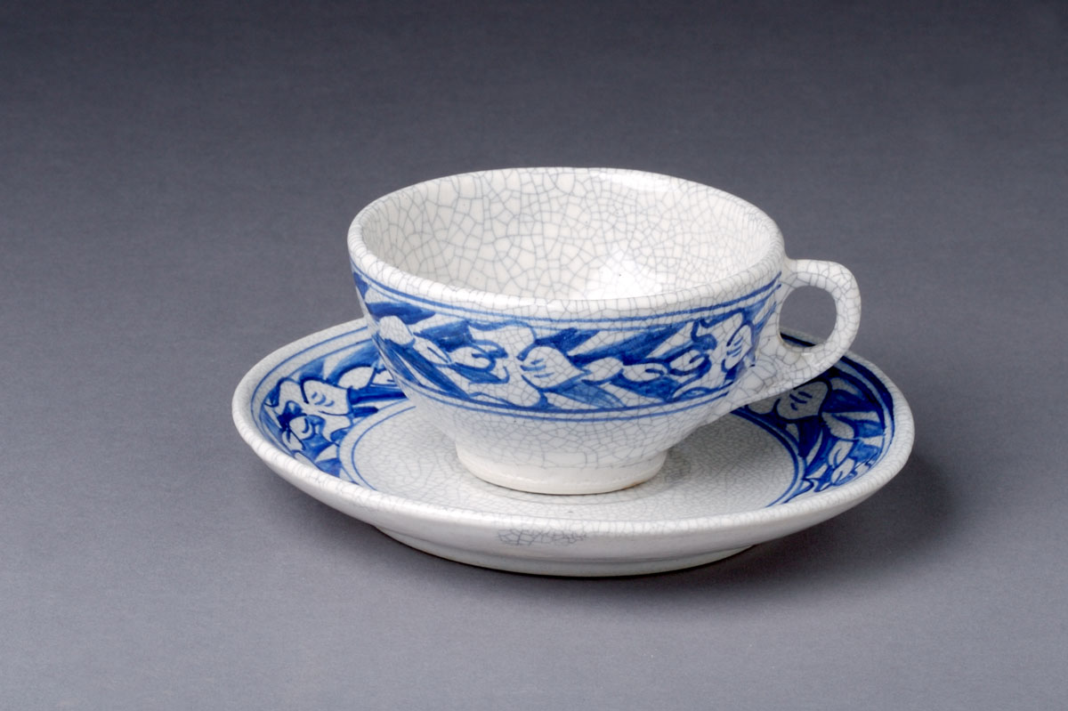 Appraisal: DEDHAM POTTERY 'IRIS' PATTERN TEACUP AND SAUCER Painted in medium