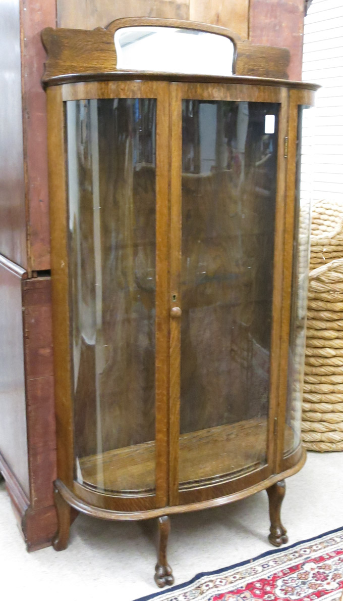 Appraisal: AN OAK AND CURVED GLASS CHINA CABINET American c featuring