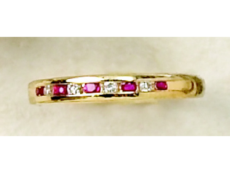 Appraisal: DIAMOND AND RUBY BAND k yellow gold channel set ring