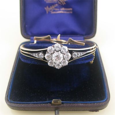 Appraisal: A late Victorian diamond cluster hinged bangle The cluster centred