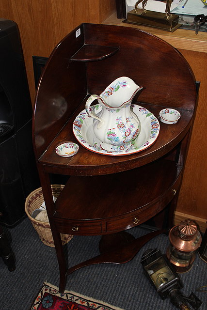 Appraisal: A GEORGE III MAHOGANY CORNER WASHSTAND complete with an old