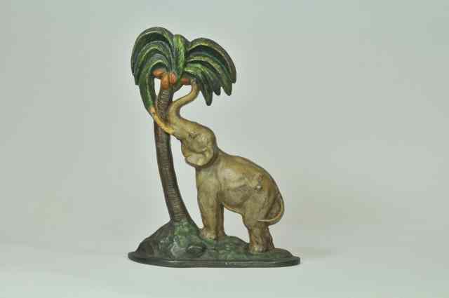 Appraisal: ELEPHANT BY COCONUT TREE DOORSTOP National Foundry great depiction of