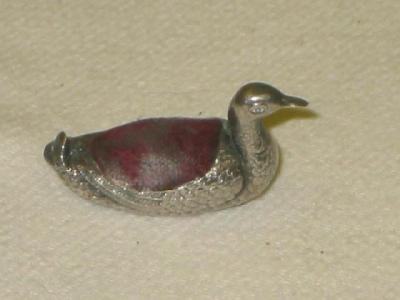 Appraisal: AN EDWARDIAN PIN CUSHION modelled as a duck with velvet