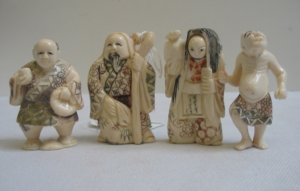 Appraisal: A GROUP OF FOUR CARVED IVORY NETSUKE including a sage