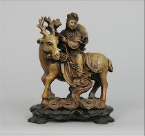 Appraisal: A Carved Soapstone Figurine with a carved wooden base A