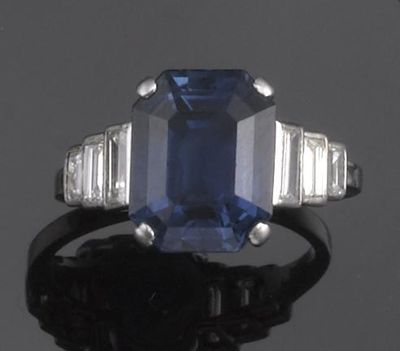 Appraisal: A sapphire and diamond ring The emerald cut sapphire is