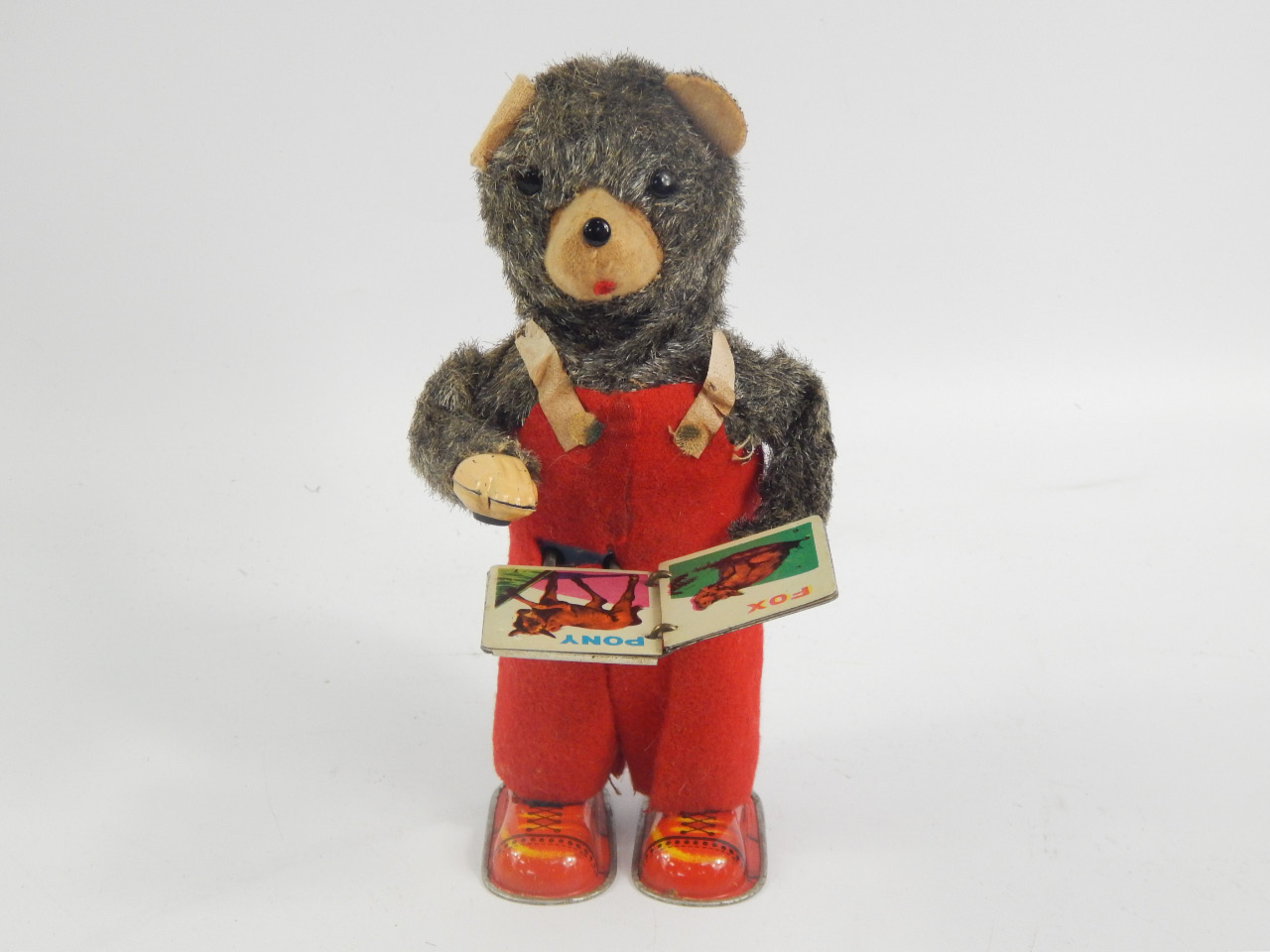 Appraisal: A Japanese tin plate clockwork Alps reading bear cm high