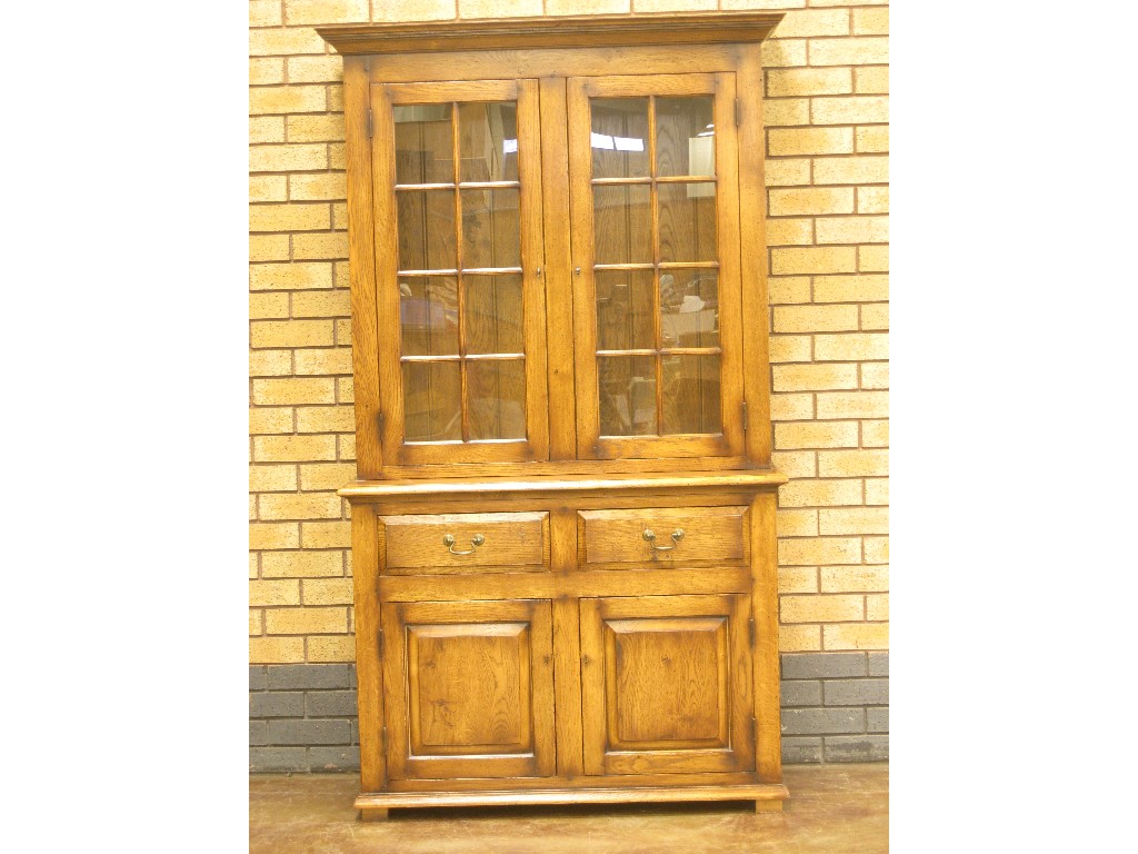 Appraisal: A reproduction oak Cabinet with pair of glazed doors above