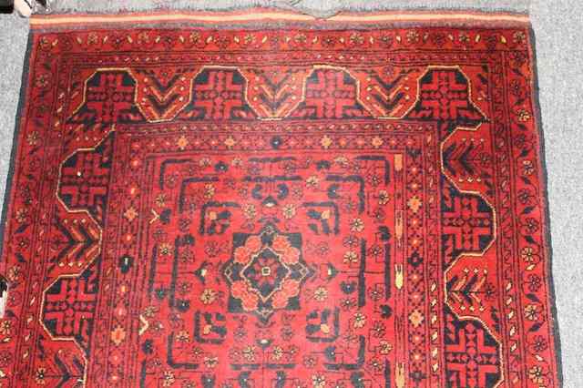 Appraisal: A PAKISTAN RED GROUND RUNNER with central panels having foliate