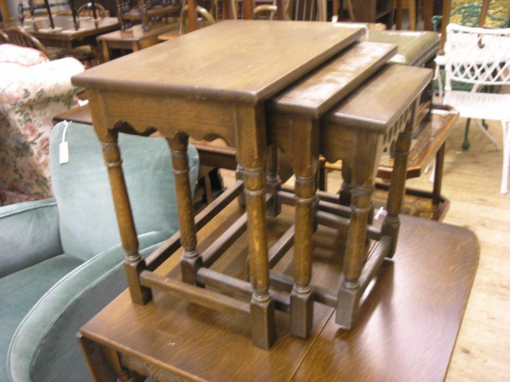 Appraisal: A dark oak nest of three tables with gouged ornament