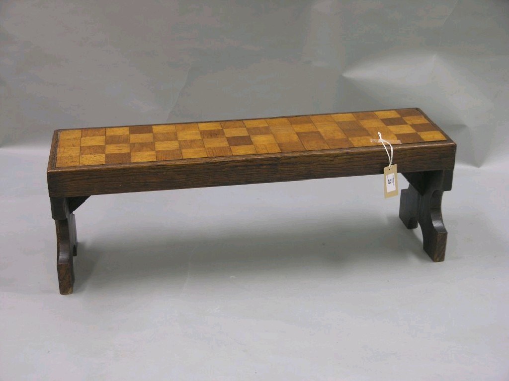 Appraisal: An oak stool with chequer inlaid top elm plank supports