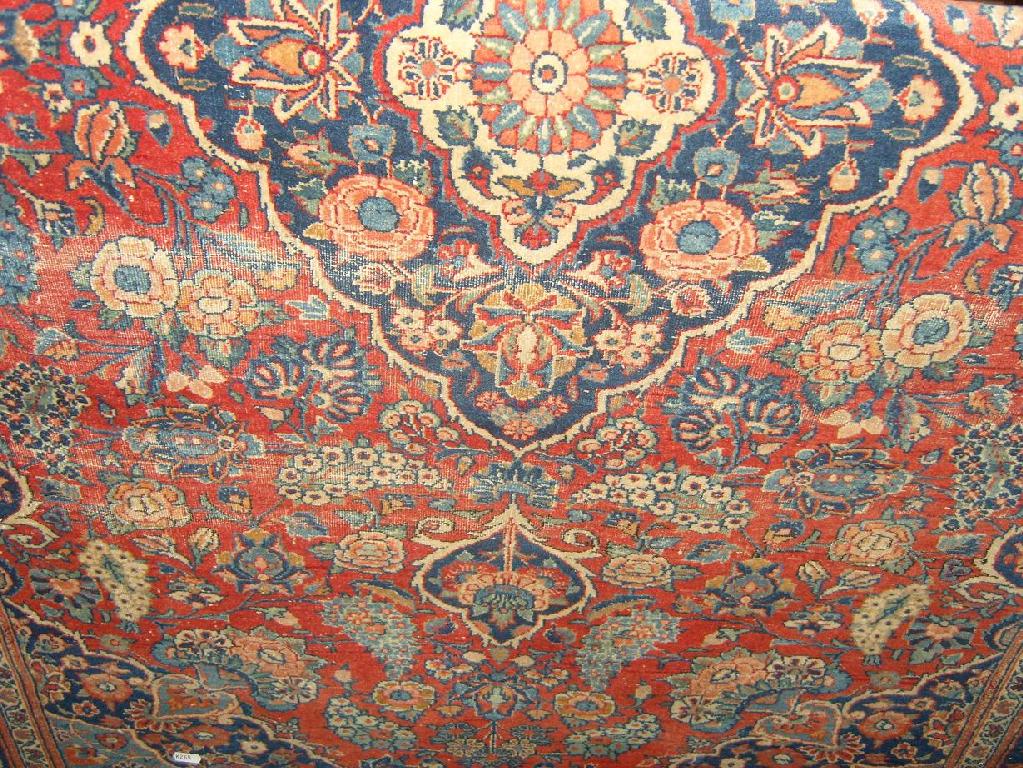 Appraisal: A red ground eastern wool rug with central medallion stylised