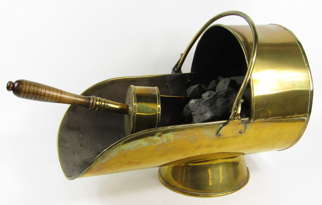 Appraisal: A Victorian brass coal scuttle of cradle form with a