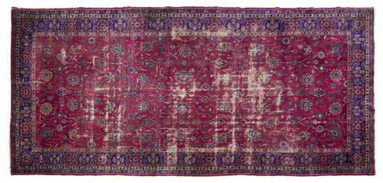 Appraisal: A Persian Wool Rug having allover foliate decoration on a