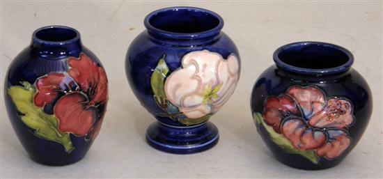 Appraisal: Three Moorcoft vases decorated with various flowers on dark blue