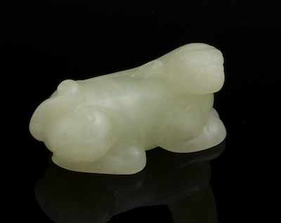 Appraisal: A Carved Jade Lion Pendent Recumbent lion carved of a