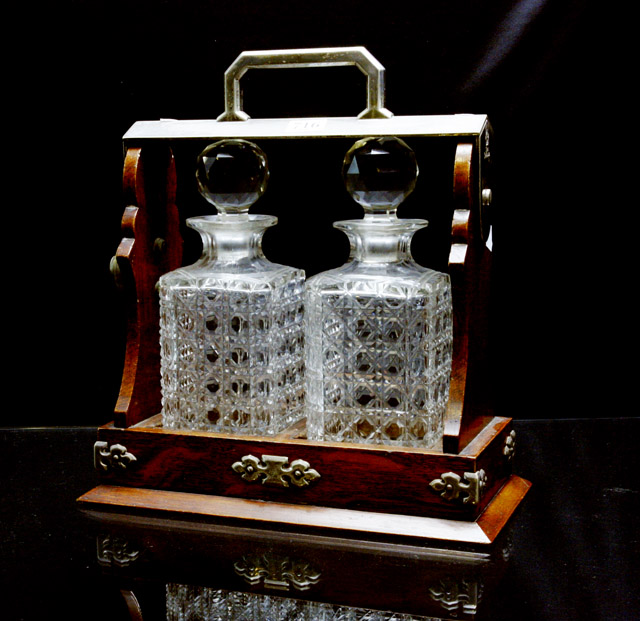 Appraisal: A timber tantalus with two cut glass decanters