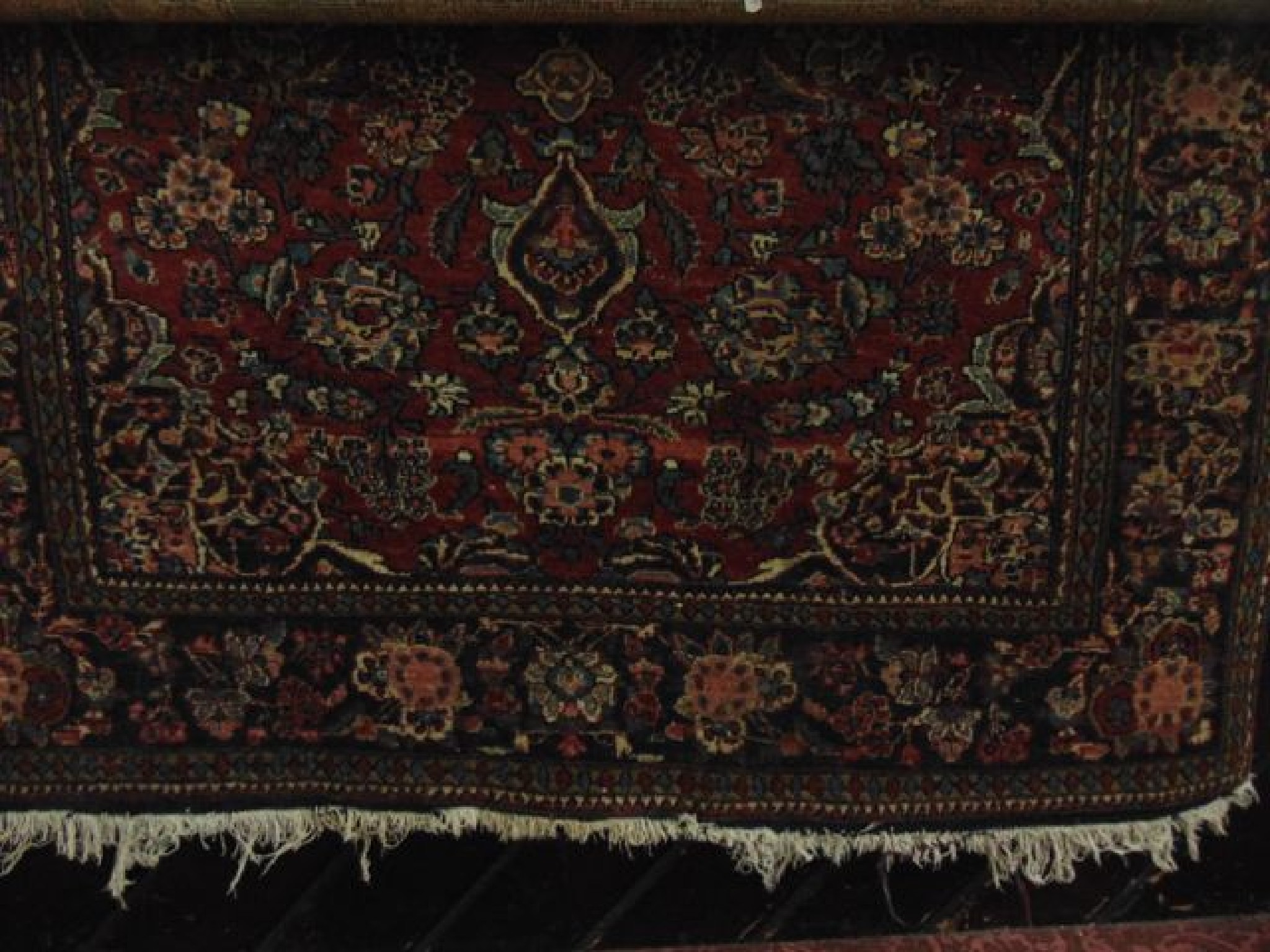 Appraisal: A Persian style wool rug with floral detail upon a