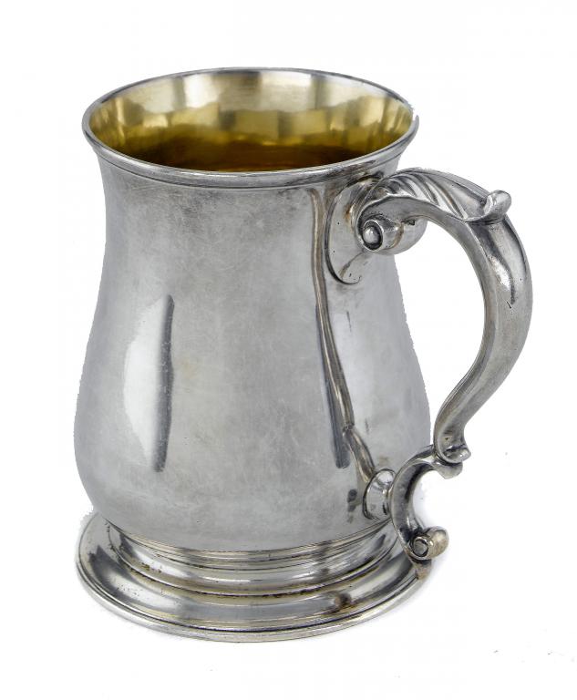 Appraisal: A GEORGE II MUG with leaf capped scrolling handle on